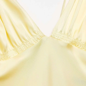 Robe midi en satin jaune pâle avec col en V profond et détails plissés élégants à la taille