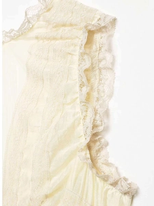 Detail shot of the delicate lace trim and pleated texture on this ivory white v-neck blouse