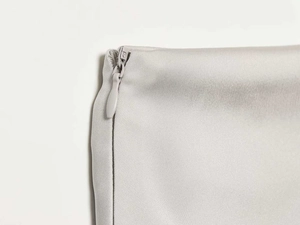 Close-up detail of silver-gray satin fabric with a hidden invisible zipper closure