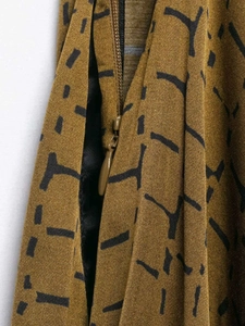 Detailed view of the ginger yellow fabric texture and invisible zipper on wide-leg pants
