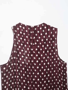 Détail d'un chemisier plissé bordeaux à pois avec fermeture zippée au col arrière