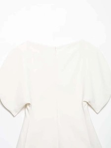 Detail of white off-shoulder top showing back invisible zipper and structured fabric texture