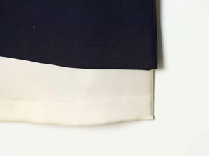 Makrodetail von dunkelblauem Twill-Gewebe mit feinen Nähten auf elfenbeinfarbenem Futter