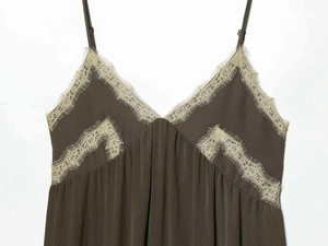Detail of olive green V-neck dress featuring delicate beige eyelash lace and ribbed fabric