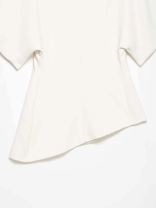 Detail of white off-the-shoulder shirt featuring asymmetrical hem and puffed sleeves