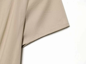 Detailed macro view showing the double-needle stitching on beige cotton-linen sleeve cuffs