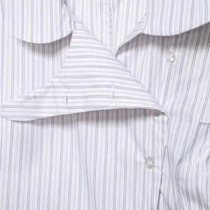 Close-up of a women's striped cotton poplin shirt with lapel collar and clear buttons