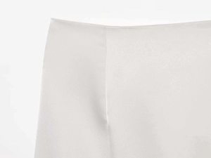 Detailed close-up showing the smooth white fabric and seamless waist stitch of this skirt