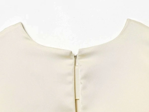 Detailansicht des Rundhalsausschnitts mit verdecktem Metallhakenverschluss am Kleid
