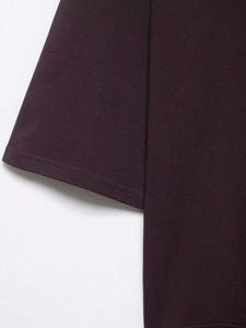 Dettaglio del top in maglia viola scuro che mostra il tessuto in cotone e le cuciture
