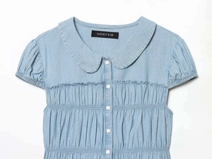 Detailed view of Peter Pan collar and ruffled pleats on light blue denim shirt