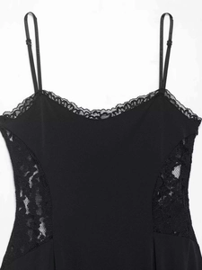Détail de la robe caraco noire avec bordure en dentelle cil et motifs floraux
