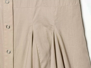 Detail shot of khaki dress fabric with metal snap button and structured pleats