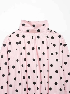 Detailed macro shot of pink polka dot blouse collar and shoulder seam craftsmanship