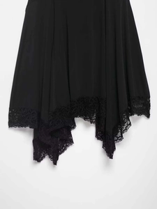 Détail de la dentelle noire sur un ourlet irrégulier de robe style mouchoir