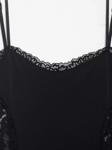 Détail d'une robe noire à bretelles avec dentelle florale délicate et fines lanières