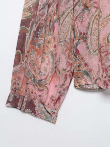 Vue macro détaillée du tissu en mousseline rose avec des motifs floraux paisley