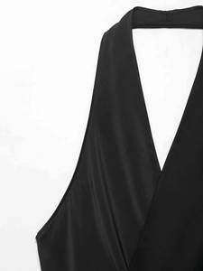 Détail d'un haut noir avec col en V profond, finitions soignées et tissu lisse de qualité