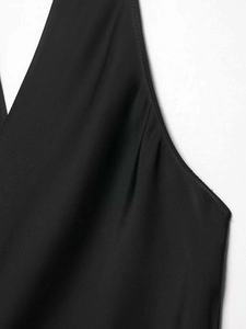 Détail de l'encolure en V et du tissu satiné lisse sur un débardeur noir sans manches