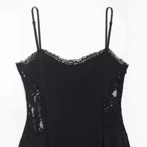 Robe noire sexy à dentelle patchwork avec bretelles réglables à boucles sur fond blanc