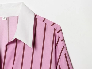 Detailed view of striped pink and white contrast collar shirt with vertical pattern