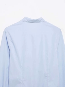Detailed back view of light blue shirt collar and shoulder seams in high quality cotton