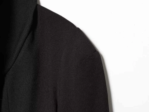 Primer plano de la solapa de blazer negro que muestra la textura de la tela de sarga