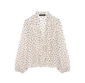Detail van chiffon stof met bruine stippen en een v-hals met sierlijke ruches