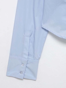 Detailed macro view of light blue shirt sleeve with double button closure and fine stitching