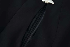 Vue détaillée de la texture du tissu noir avec boucle en métal argenté et fermeture éclair