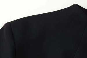 Vue détaillée de la couture de l'épaule et du tissu tissé d'une robe noire cintrée
