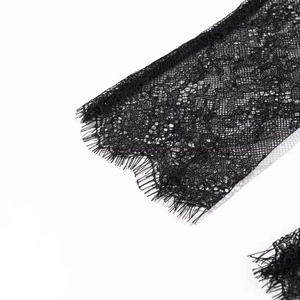 Macro detail of delicate black eyelash lace trim with intricate floral patterns