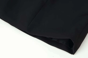Détail de la couture et de l'ourlet sur une robe noire tissée avec doublure assortie