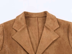 Gros plan d'un manteau en daim marron montrant la texture fine et les coutures