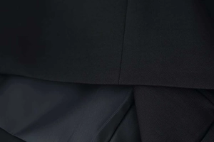 Vue macro d'un tissu de robe noir de qualité montrant la texture fine et la doublure soyeuse