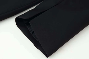 Détail de la fente latérale d'une robe noire avec doublure en soie et tissu texturé