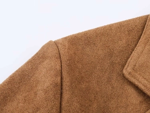 Détail de la couture d'épaule et du revers d'un trench-coat marron en texture suédine