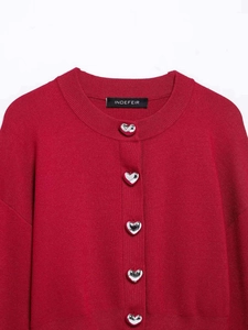 Detail of red crewneck cardigan featuring vintage silver heart-shaped metal buttons