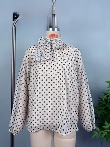 Close-up of elegant polka dot chiffon shirt featuring high neck tie bow and lantern sleeves