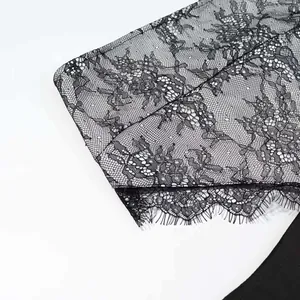 Detailed macro shot of premium black floral eyelash lace trim on backless summer dress