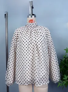Detailed view of the vintage polka dot chiffon blouse with a high neck and lantern sleeves