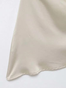 Detailed close-up showing the smooth champagne satin fabric and refined hem stitching