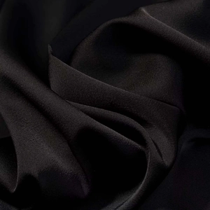 Detailed close-up of smooth black satin fabric with elegant drape and soft luxury texture