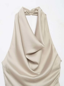 Detailed view of champagne satin halter top neck with pleats and button closure