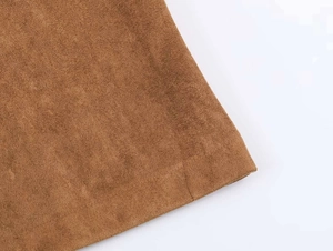 Détail du tissu en daim marron d'un trench-coat avec texture mate et couture fine