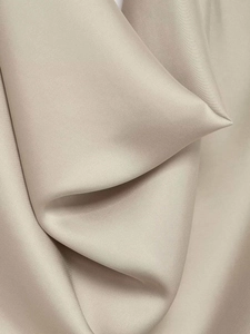 Detail shot of champagne satin fabric showing soft silky texture and elegant draping