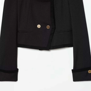 Chaqueta corta negra con botones dorados en relieve y elegantes bordes de terciopelo