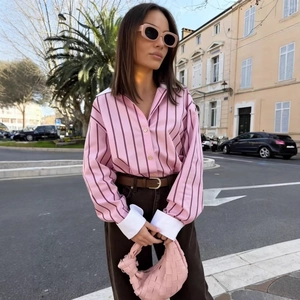 Pink striped shirt with white contrast collar and brown pants on a European street