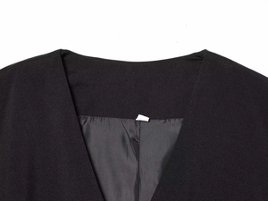Detail of a black V-neck blazer romper showing fine twill texture and satin lining