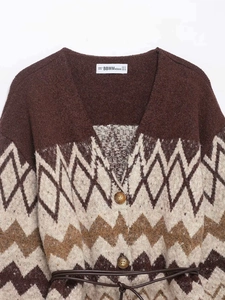 Detail of V-neck knitted cardigan with brown geometric pattern and leather belt